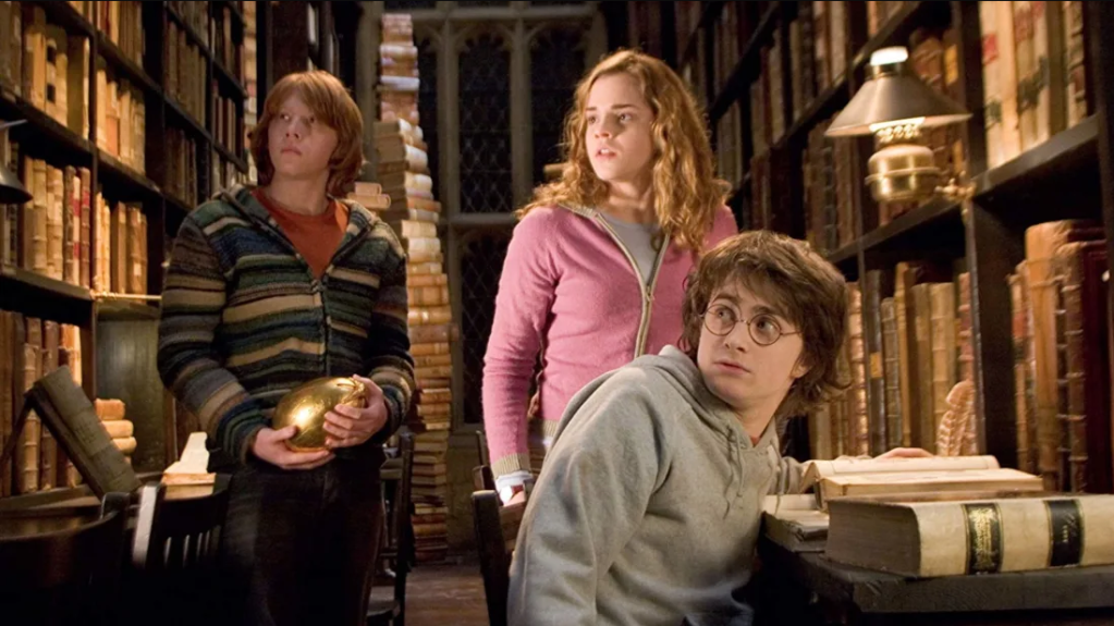 Harry Potter Cena do filme 'Harry Potter', com os três protagonistas na biblioteca