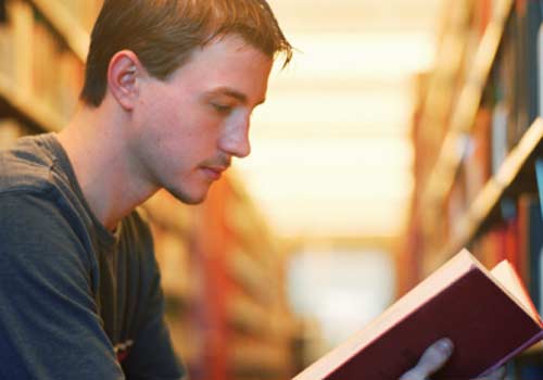 aluno-lendo-livro-biblioteca.jpg