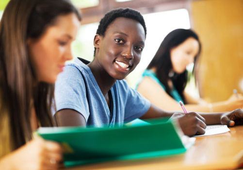 estudante-sorri-foto-mesa-estudos.jpg