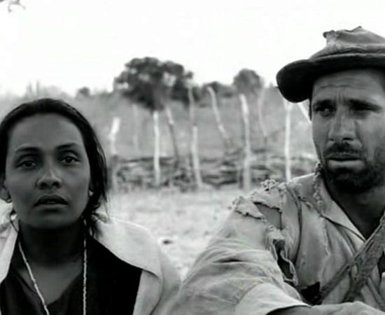 Vidas Secas (1963), dirigido por Nelson Pereira dos Santos, é baseado no livro homônimo do escritor Graciliano Ramos. Pressionados pela seca, uma família de retirantes composta por Fabiano, Sinhá Vitória, o menino mais velho, o menino mais novo e a cachorra Baleia, atravessam o sertão em busca de meios para sobreviver. Vidas Secas (1963), dirigido por Nelson Pereira dos Santos, é baseado no livro homônimo do escritor Graciliano Ramos. Pressionados pela seca, uma família de retirantes composta por Fabiano, Sinhá Vitória, o menino mais velho, o menino mais novo e a cachorra Baleia, atravessam o sertão em busca de meios para sobreviver.