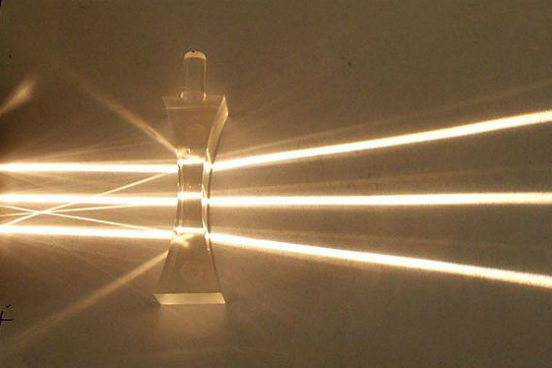Nas lentes divergentes, os raios de luz paralelos entre si que incidem sobre a lente são refratados em direções diferentes, que acabam divergindo em um mesmo ponto. (Imagem: Wikimedia Commons) Nas lentes divergentes, os raios de luz paralelos entre si que incidem sobre a lente são refratados em direções diferentes, que acabam divergindo em um mesmo ponto. (Imagem: Wikimedia Commons)