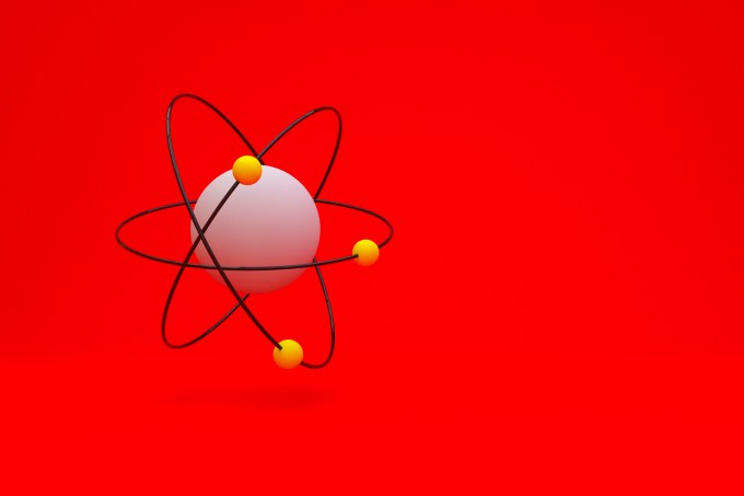 Model of atom with shadow on red background, 3D