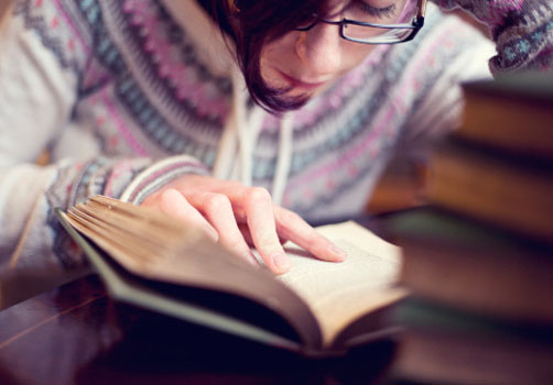 menina-leitura-pilha-livros.jpg