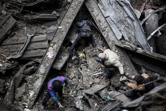 Soldados ucranianos feitos prisioneiros de guerra são forçados pelos rebeldes pró-russas a buscar por corpos e armamentos entre os destroços do aeroporto de Donetsk. (Foto: Andrew Burton / Getty Images)