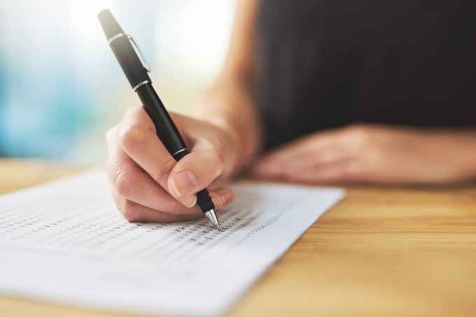 Shot of a woman filling in an answer sheet for a test