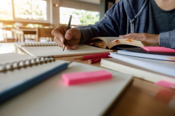 Estudante escrevendo em um caderno