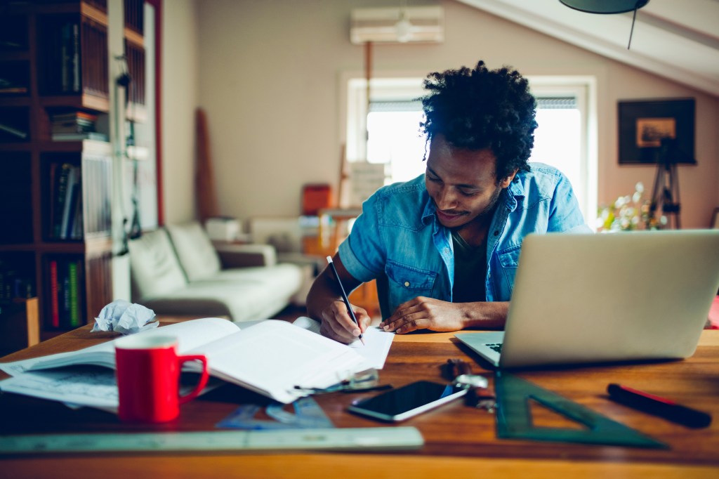 Aluno estudando, livros, réguas, computador, escrevendo