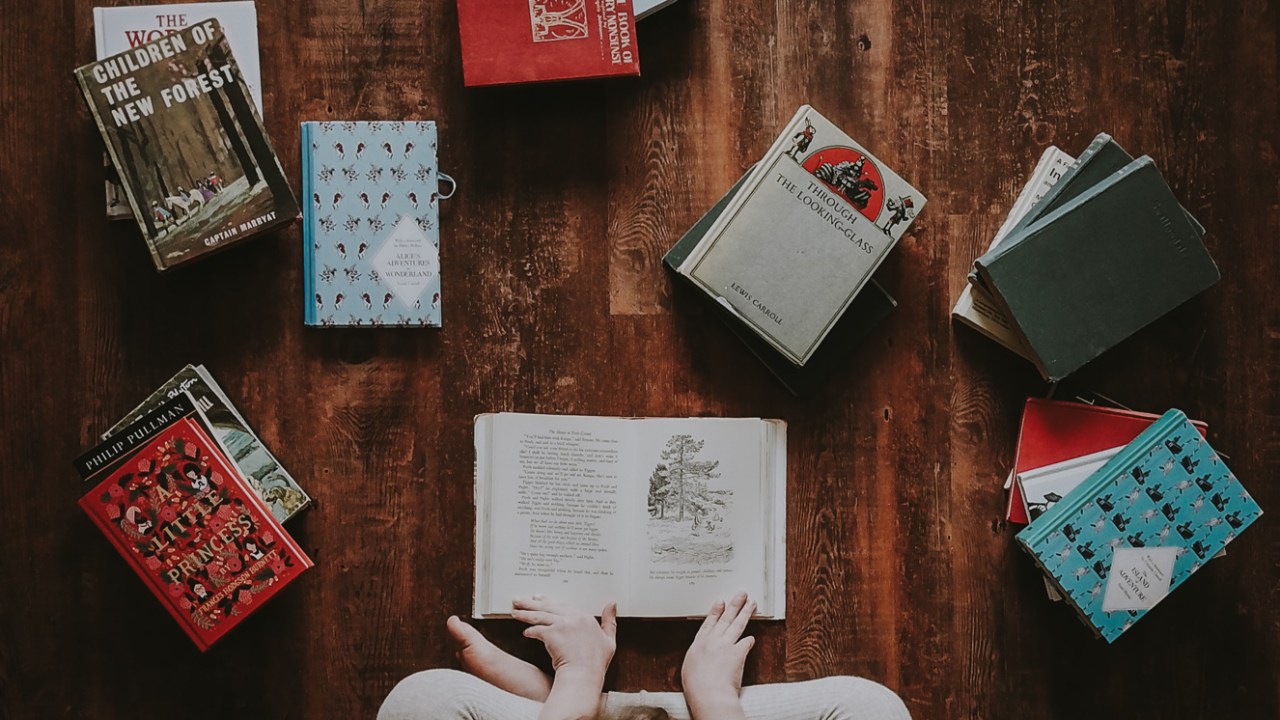 Pessoa sentada no chão lendo um livro