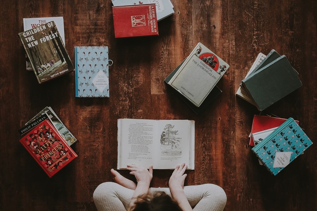 Pessoa sentada no chão lendo um livro