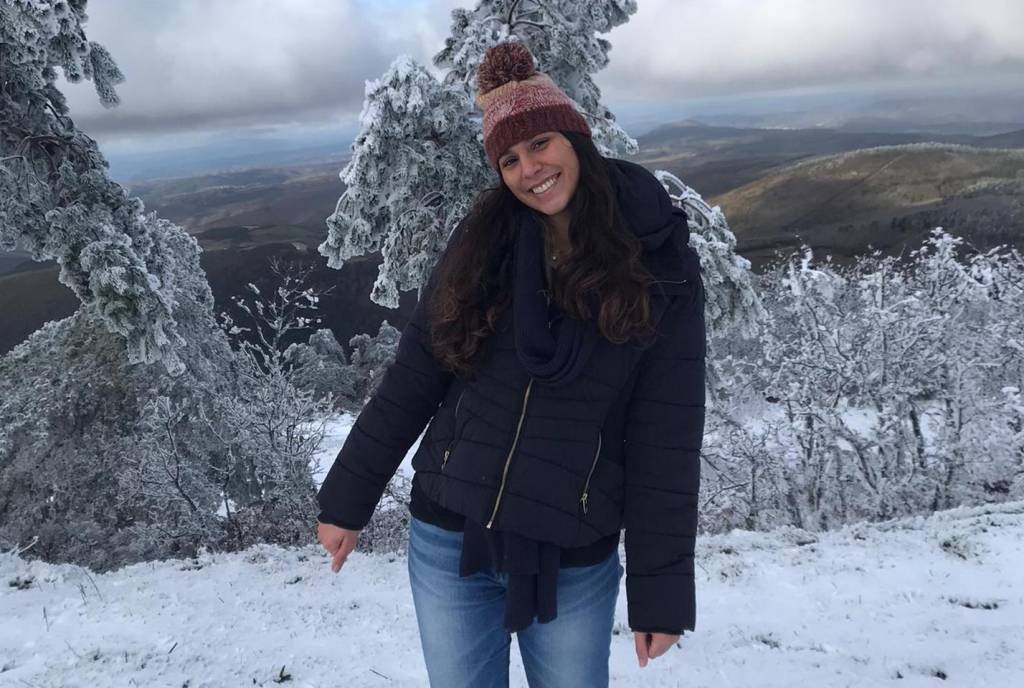 Estudando em Portugal 4 Com roupas de frio e touca, mulher posa feliz em meio à neve