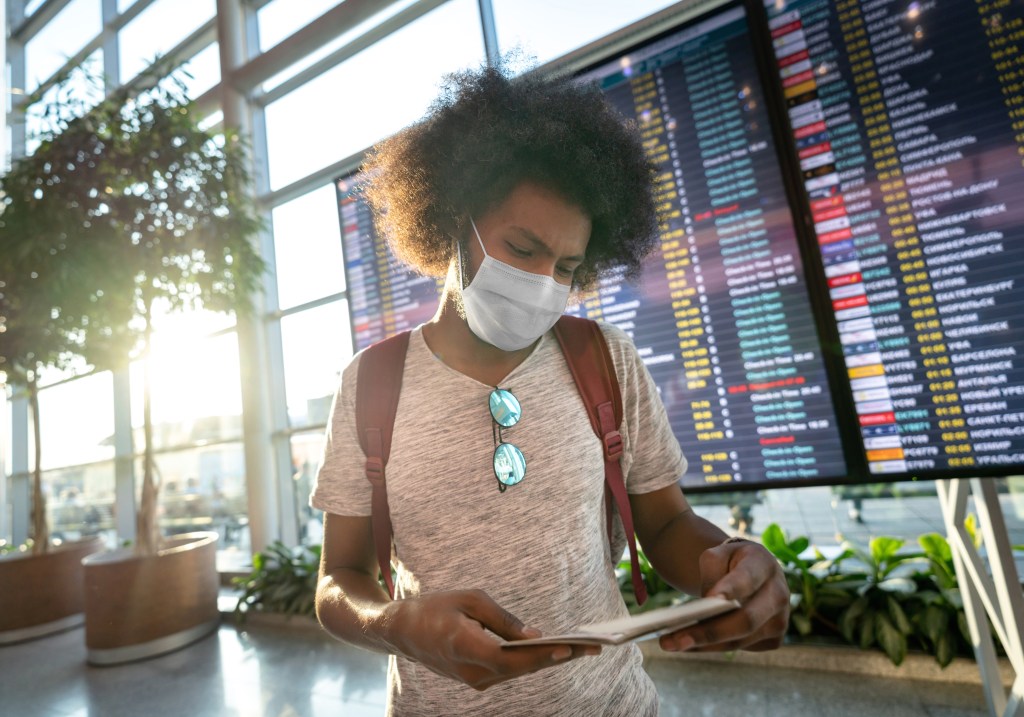 Estudante usando máscara no aeroporto