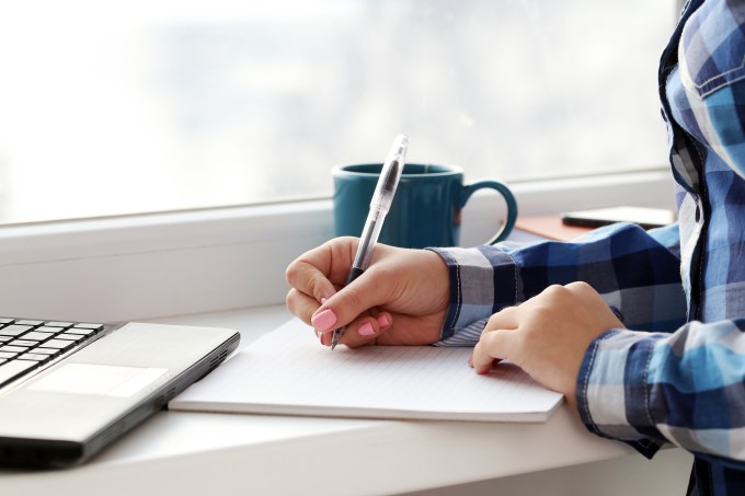 Woman writes in notebook