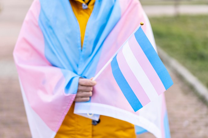 Woman covered with the transgender flag on a protest