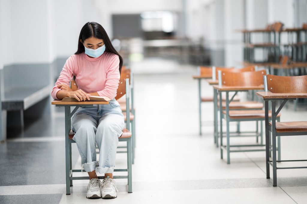 Estudante de máscara em uma sala de aula