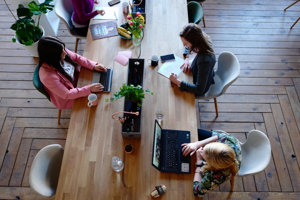 Pessoas trabalhando com os seus notebooks em uma mesa