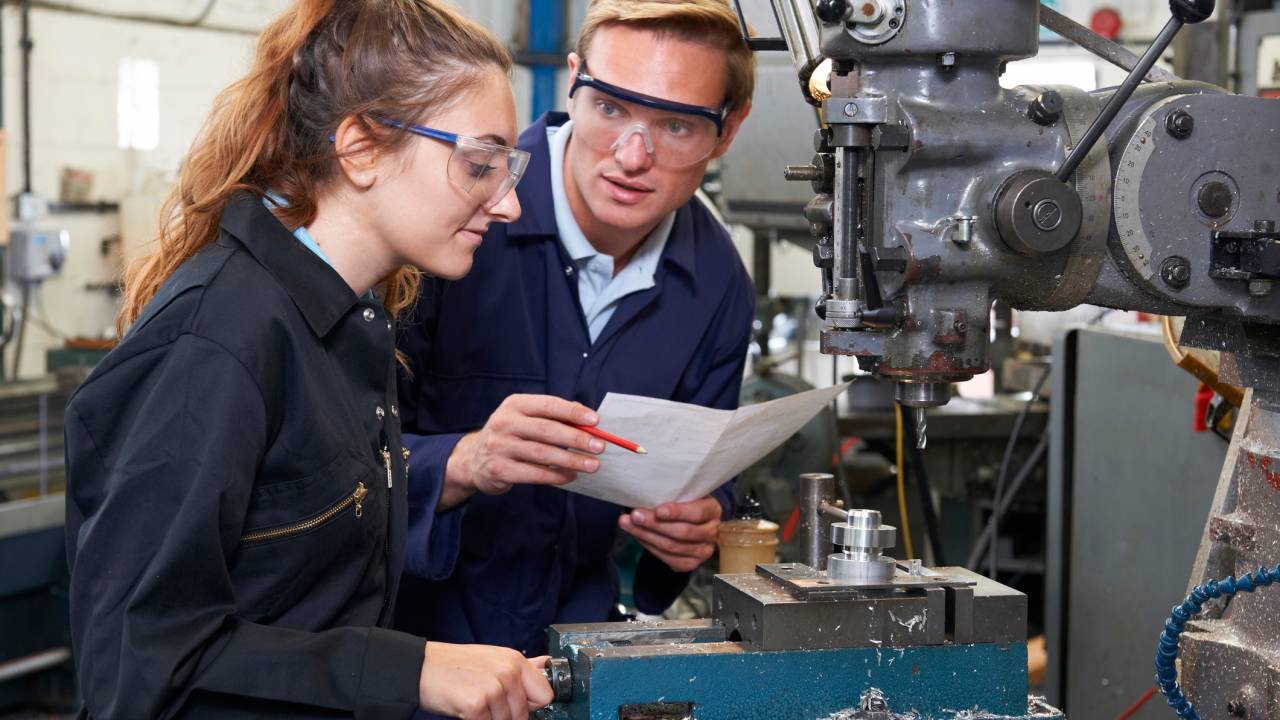 Engenheiro mostrando ao aprendiz como usar o Drill In Factory