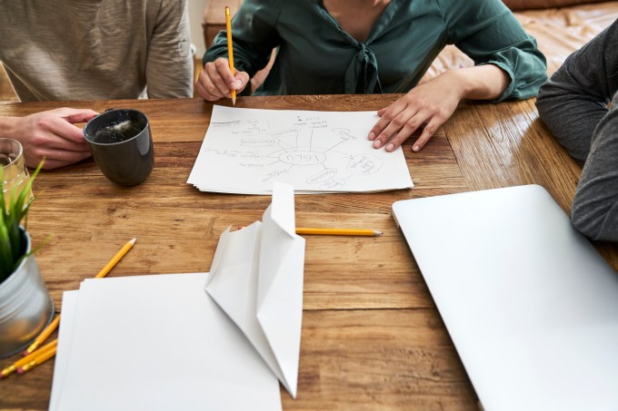 Coworkers working together and taking notes at table in office