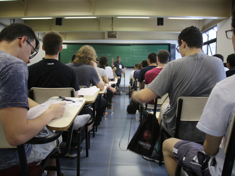 estudantes na sala de aula e o professor ao fundo