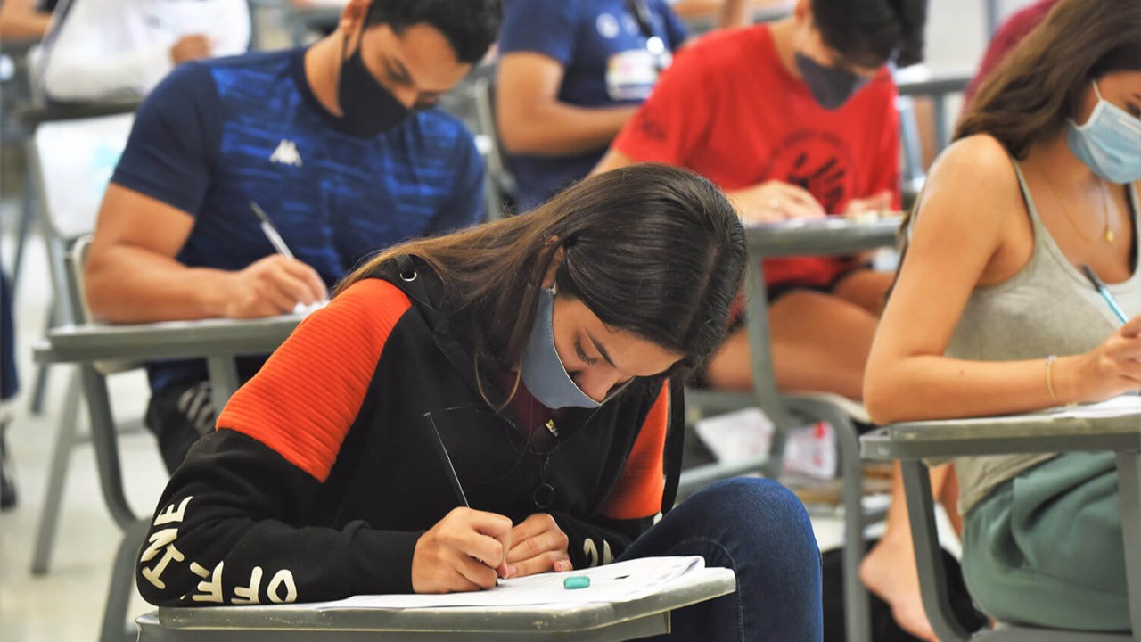 Sala de aula com candidatos usando máscara fazendo a prova do vestibular