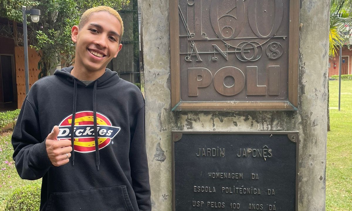 Gabriel posa para foto ao lado de placa da Poli-USP