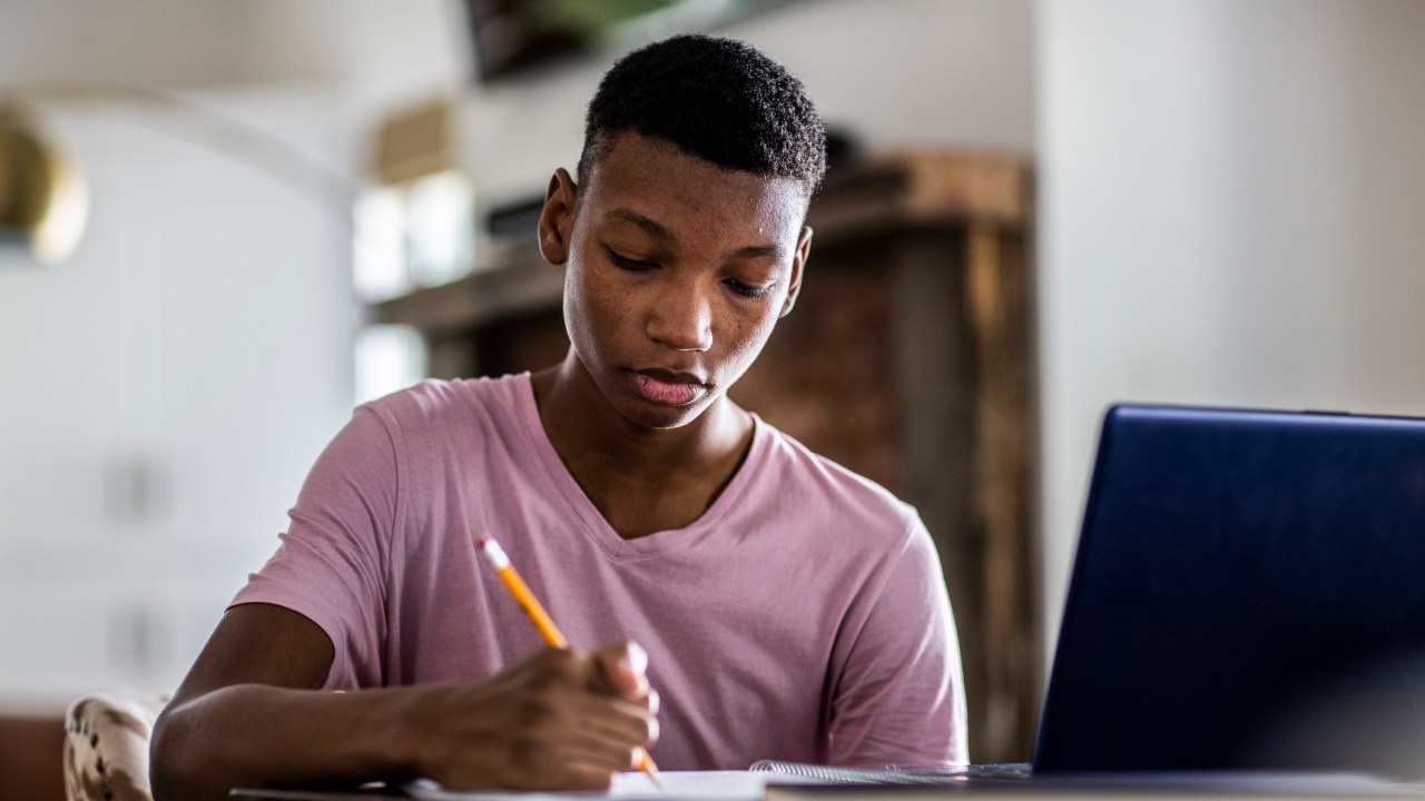 estudante no computador; estudando; escrevendo