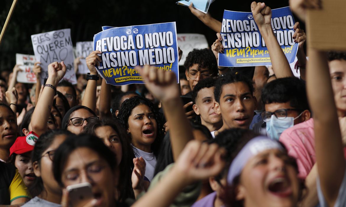 Estudantes secundaristas em manifestação contra a implementação do Novo Ensino Médio, na Avenida Paulista. Eles carregam cartazes pedindo a revogação do Modelo