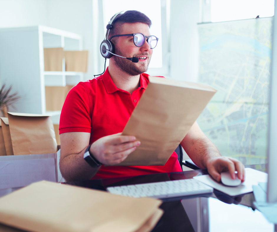 Homem segurando e selecionando envelopes, na frente de um computador