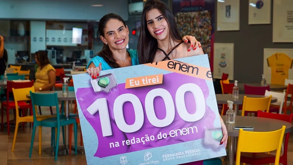 Fernanda-Pessoa-Carina-Moura A professora Fernanda Pessoa e a estudante Carina Moura, as duas seguram juntas um cartaz escrito