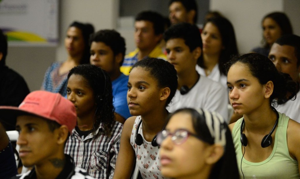 Grupo de jovens sentados olhando para a direita