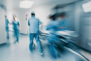 Cena de equipe médica levando uma maca hospitalar por um hospital