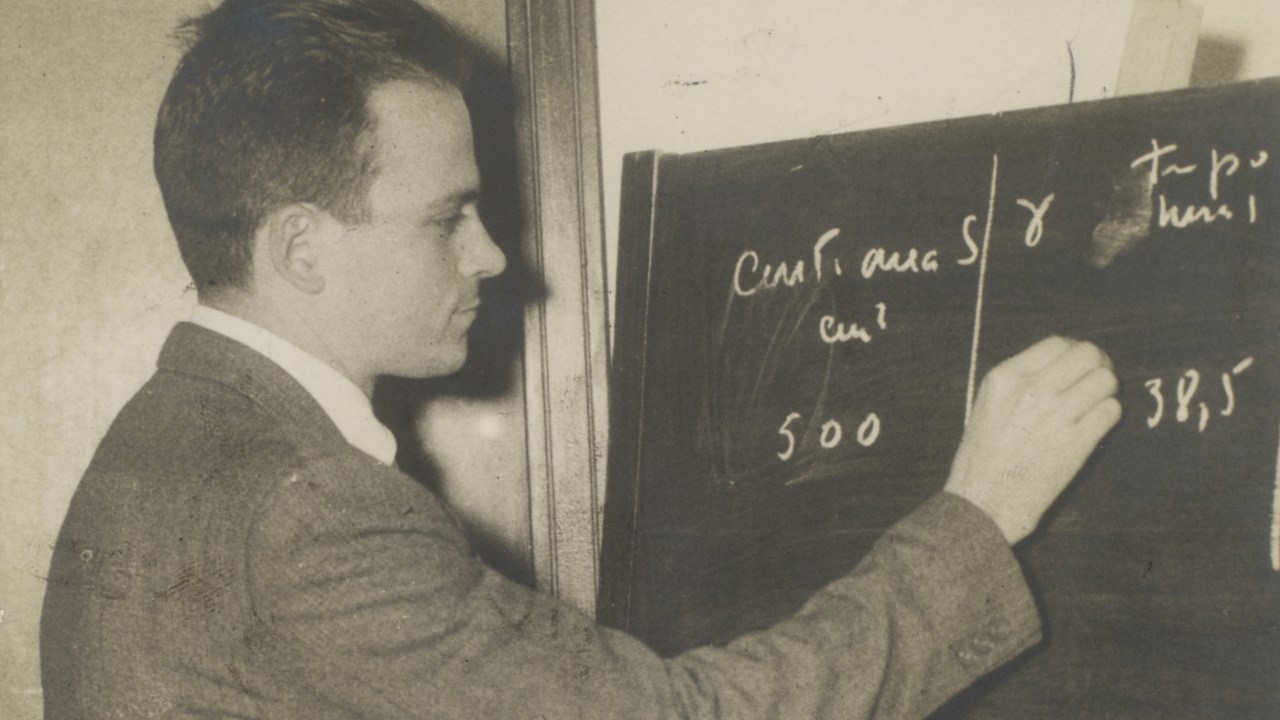 César Lattes escrevendo em uma lousa