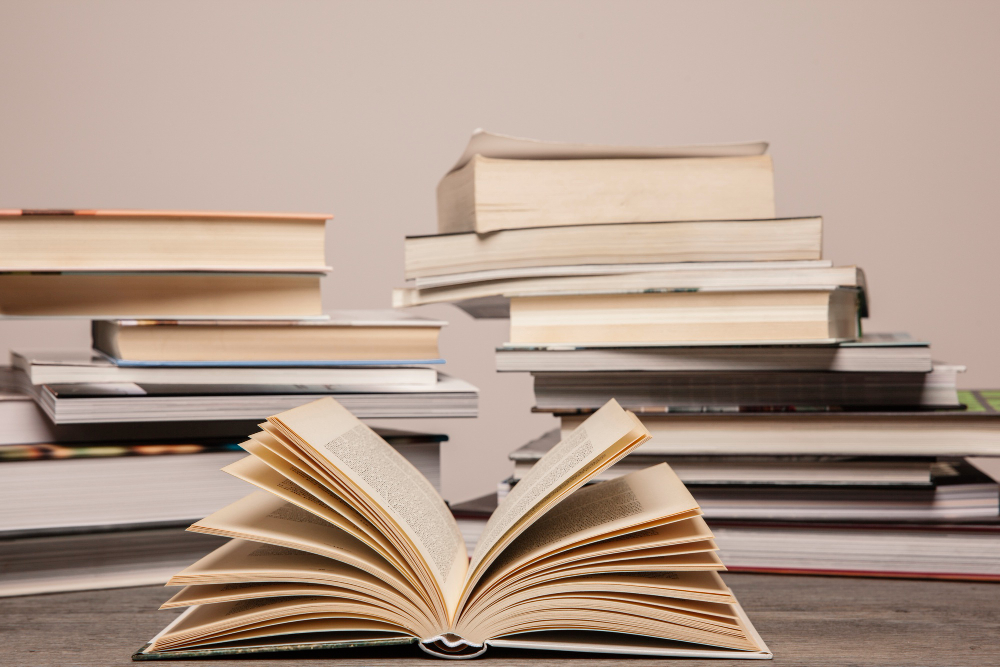 linguagens-e-codigos Pilha de livros, com o livro da frente aberto