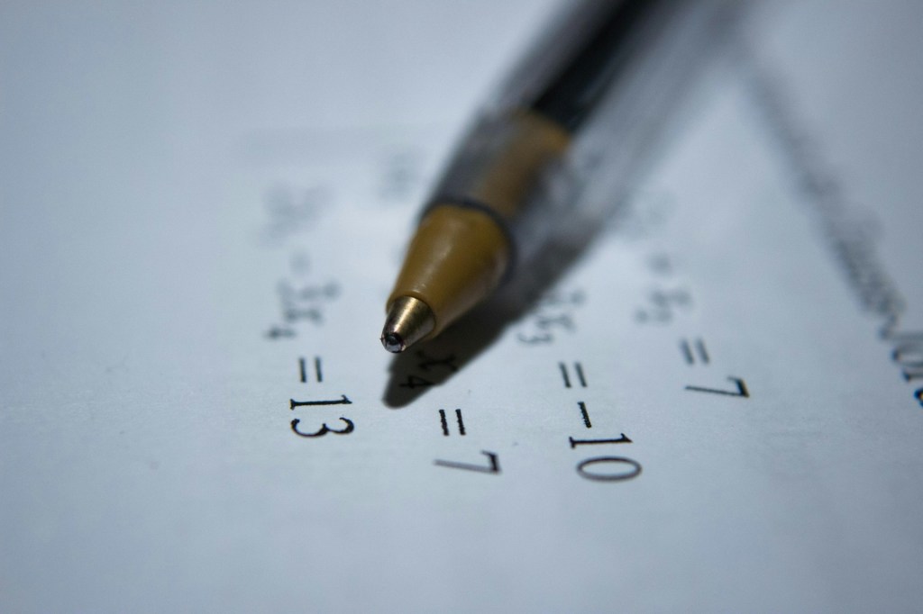 matematica Papel de contas com close de ponta de uma caneta esfereográfica