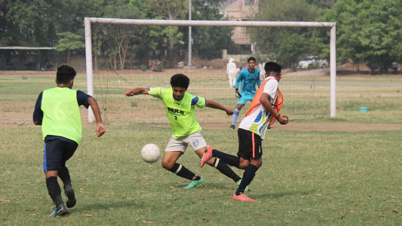 Jovens jogando futebol em campinho