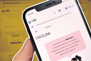 Montagem mostra mão segurando celular com tela aberta no site do Prouni. Atrás, há um fundo amarelo estilizado com textura