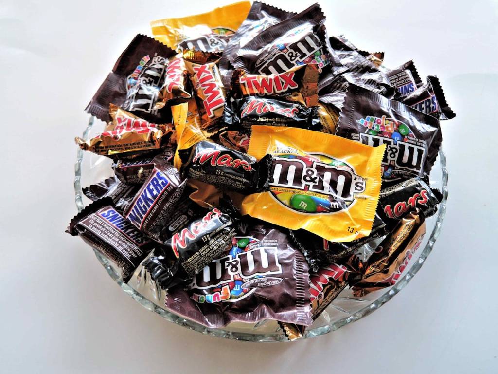 açúcar pote com vários doces industrializados, como MMs e Twix.