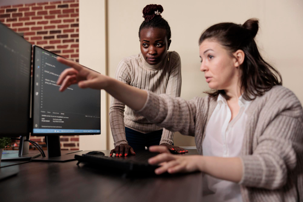 trabalho-computador Duas melhores conversam trabalham em frente a computador