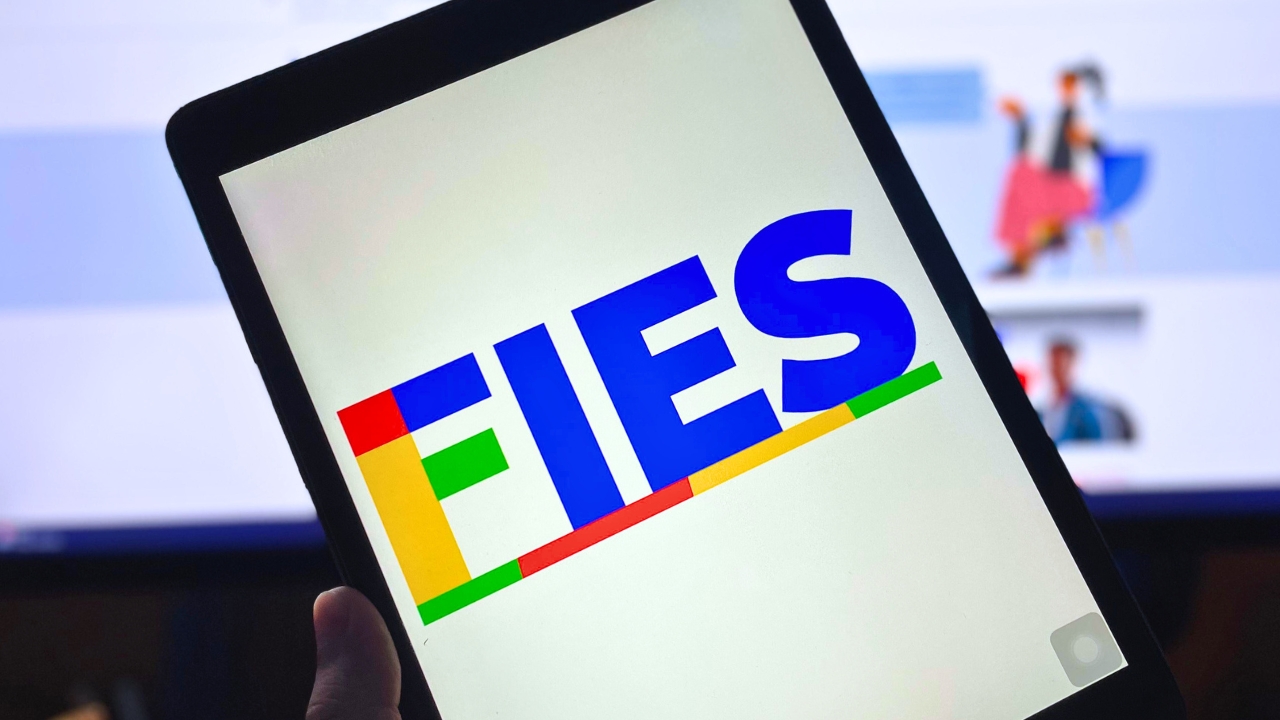 Tablet com logo do Fies à frente de tela de monitor com site do Fies aberto